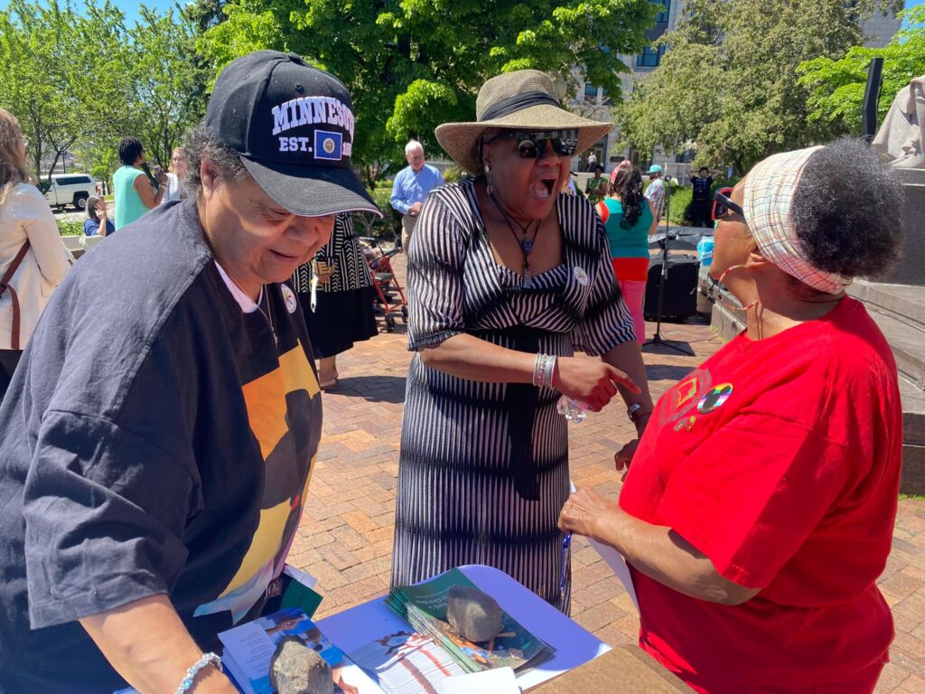 Three women in conversation at Juneteenth Elders Luncheon