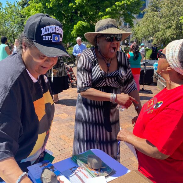 Three women in conversation at Juneteenth Elders Luncheon