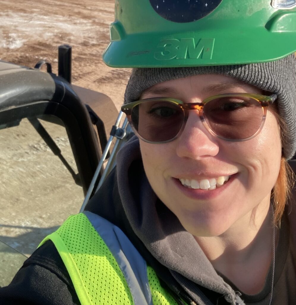Smiling woman wearing green construction hardhat